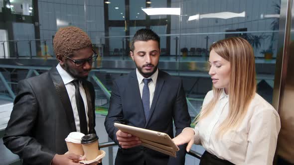 Colleagues in elevator with tablet computer