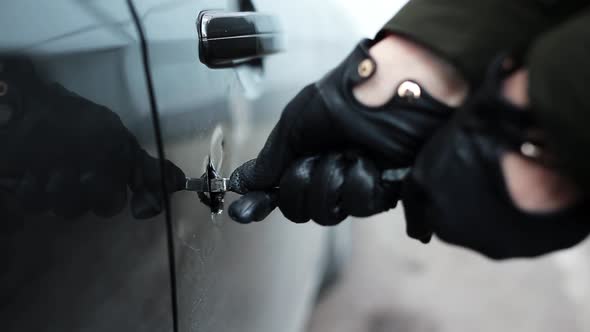 Hands in Black Leather Glove Holding Metallic Stick Make Huge Hole in Car Door