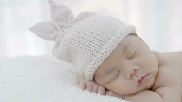 Close up of Asian baby laying on a soft blanket, Slow motion shot alt