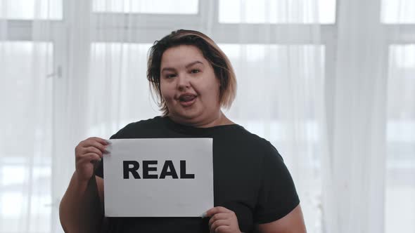 Concept Body Positivity a Fat Charismatic Woman Holds a Sign with the Inscription REAL Looking in alt