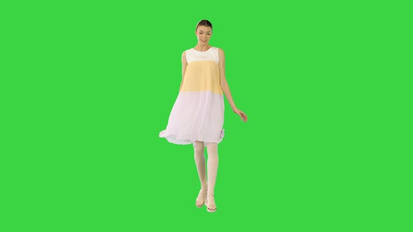 Young Beautiful Girl in Whiteyellow Dress Runs Seemingly Happy on a Green Screen Chroma Key