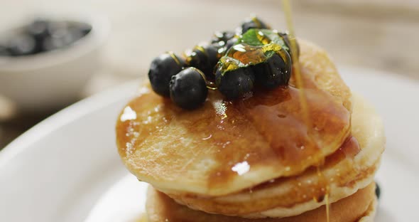 Video of pancakes on plate seen from above on wooden background alt