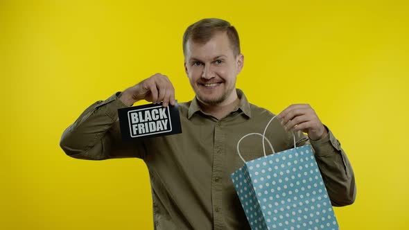 Attractive Man Showing Black Friday Inscription From Shopping Bag, Smiling, Rejoicing Discounts alt