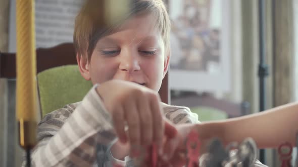 Intelligent Boy Playing Chess at Home He is Moving a Piece on the Chessboard