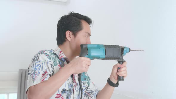 Asian Man Use Electric Drill On Wall In Him House, Home Improvement And Repairs alt