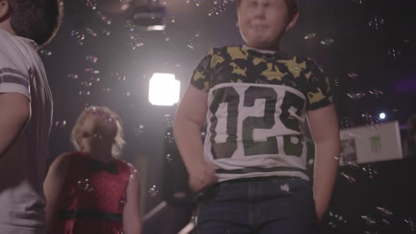 Kids Dancing and Bouncing Up & Down With Bubbles Floating Around, in Slow Motion - Ungraded alt