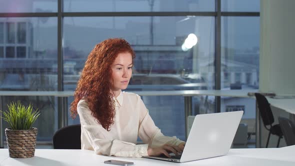 Businesswoman in Office with Laptop Computer.