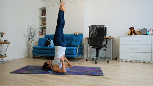 Young Woman Does Supported Shoulderstand Yoga Pose