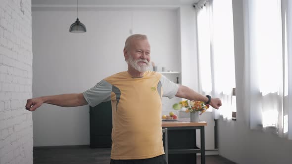 Wellness Exercises, an Elderly Male Takes Care of Health Performs Exercises Waving Arms While alt