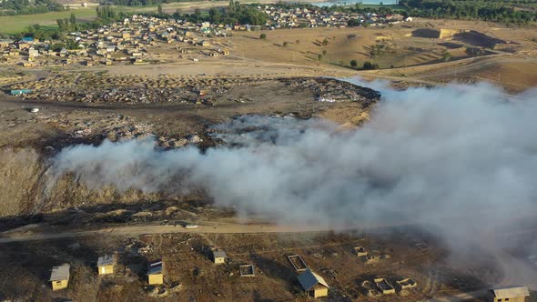Aerial view of burning garbage pile in trash dump or landfill alt