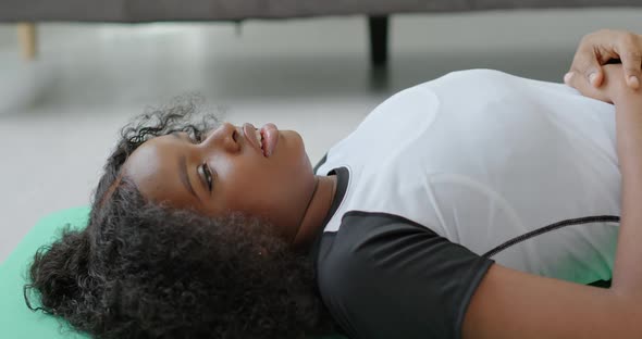 Beautiful Black African American Girl Lies Down on the Ground Takes a Deep Breath After Training alt