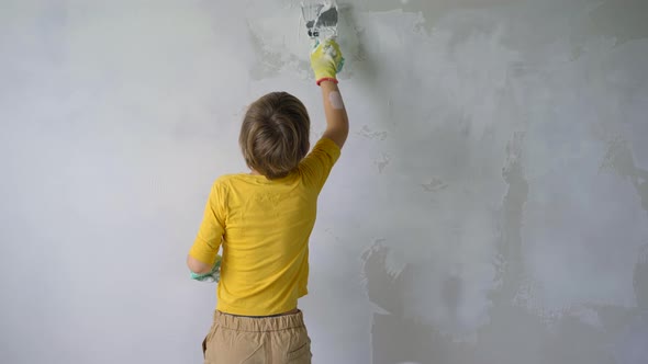 A Boy is Applying Putty to the Wall alt