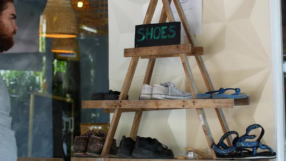 Shelf with Shoes, a Man Changes Shoes