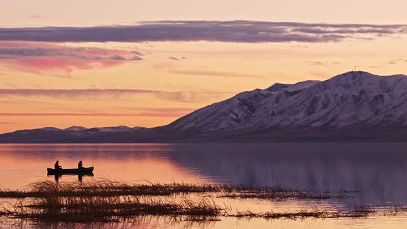 People floating in a canoe during sunset over Utah Lake alt