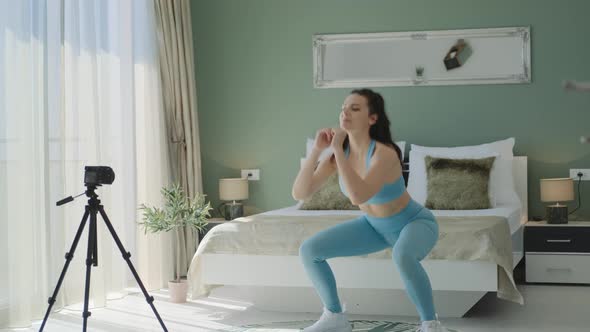 Athletic Female Blogger in blue sportswear recording video alt