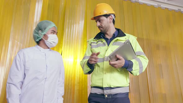 Asian male supervisor and caucasian manager inspecting bottle of herb drink alt