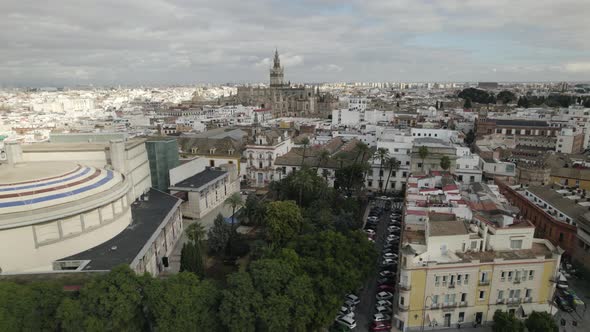 Pullback from Seville Cathedral cityscape flyover Theater de la Maestranza. Spain