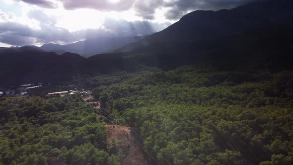 Tranquil Landscape of the Green Forest and Little Village Surrounded By Mountain Ridge alt