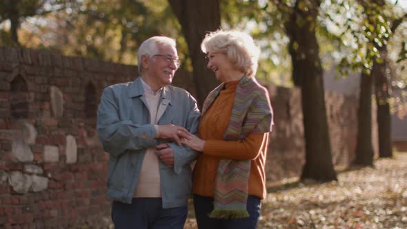 Handsome senior couple embracing in autumn park