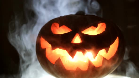 Shining Jack-O-Lantern. Halloween Pumpkin with Scary Face Smoke Inside with Flame.