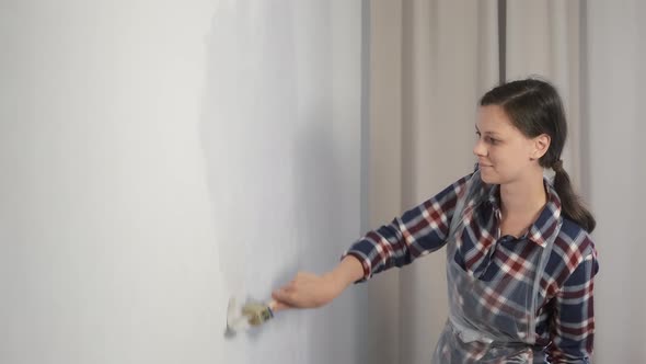 Woman House Painter is Painting Wall Using Brush Doing Renovation at Home