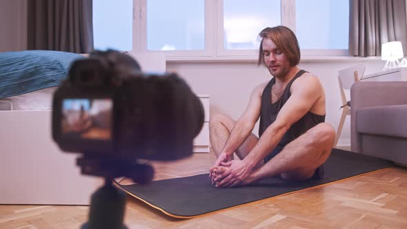Young Man Stretching and Streaming Exercise Class alt