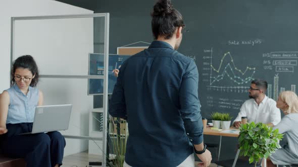 Back View of Arab Man Walking in Office Meeting Colleagues Then Watching Presentation with Digital alt