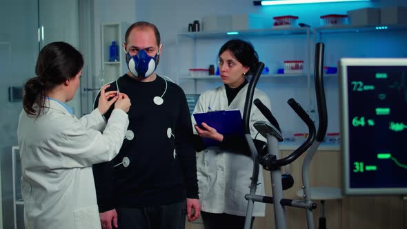 Scientist Researcher Preparing Man Patient for Endurance Test alt