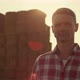 Farmer Posing Hay Bales in Sunlight Portrait - VideoHive Item for Sale