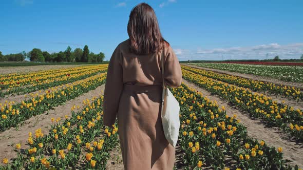 Woman walking through a field of tulips