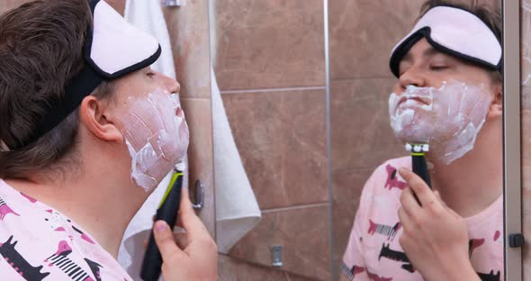 Plump Man with Cream on Face Shaves Looking in Mirror