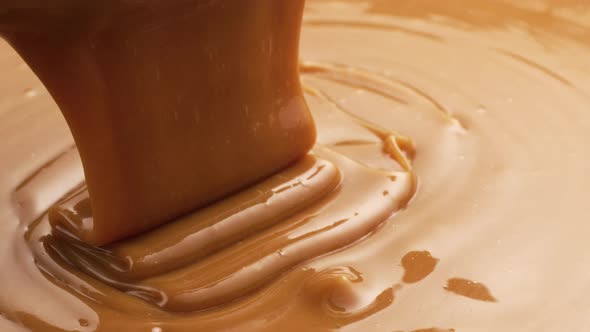 Pouring melted caramel, closeup food shot. 