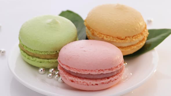 French Dessert Sweets Colored Macaroons Cookies Arranged on While Plate Rotating