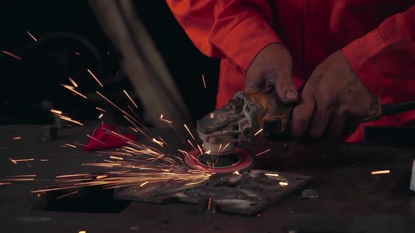 Professional mechanic is cutting steel metal. alt