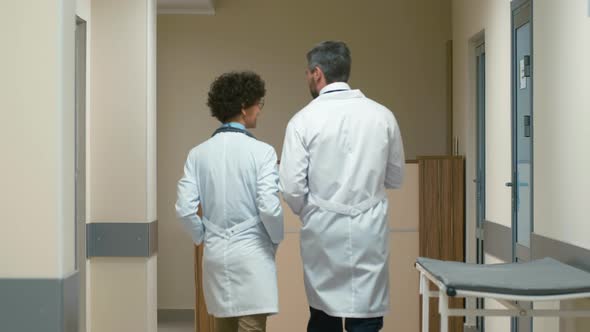 Two doctors walking through corridor