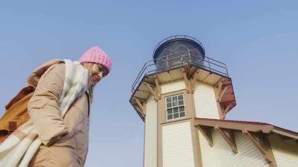 Low Angle Shot of Attractive Woman Walking Around Lighthouse Tower at Sunrise 6K alt