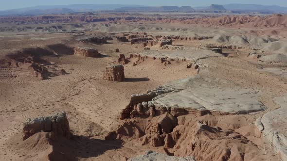 Aerial shot flying over southern Utah desert with unique canyons and rock formations in the distance alt