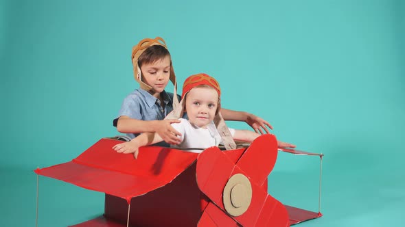Excited Little Boys Flying on Red Toy Airplane alt
