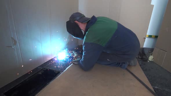 Factory worker welds metal. The man is welding. Welding with argon or electrode, using a welding mac