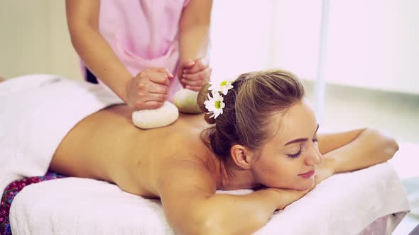 Massage Therapist Using Herbal Compress on Woman alt