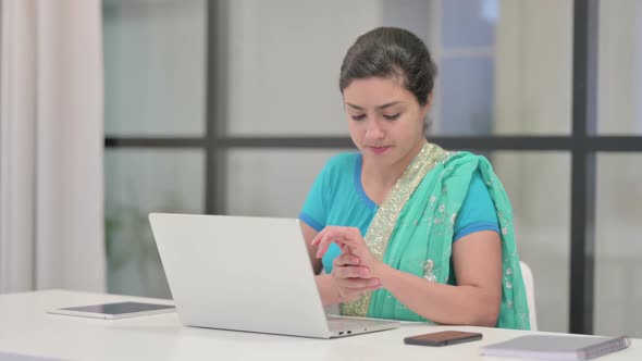 Indian Woman Having Wrist Pain While Using Laptop in Office alt
