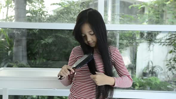Asian Girl Use Comb Brushing  hair alt