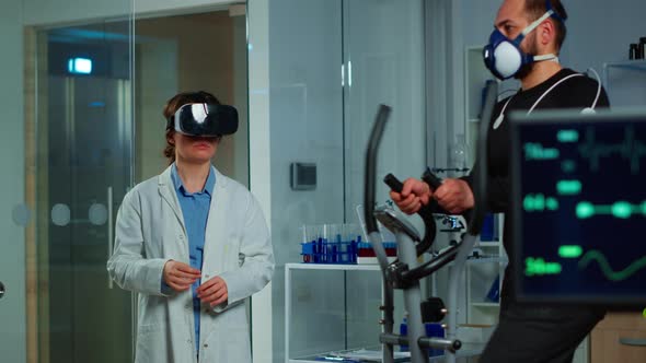 Scientist Doctor in Sport Science Laboratory Wearing Virtual Reality Goggles alt