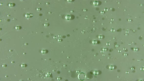 Green Liquid Cream Cosmetic Gel Fluid Motion Rotation on a Surface alt