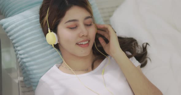 Close Up Happy Asian Woman Listening To Music By Headphones. alt