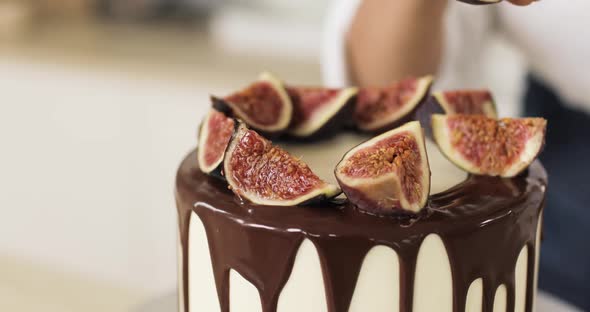 The Pastry Chef Decorates a Caramel Cake or Cheesecake with Figs