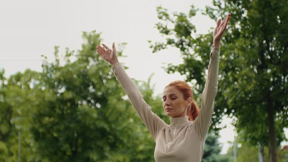 Girl practices yoga, rising arms up and breathing deep. alt