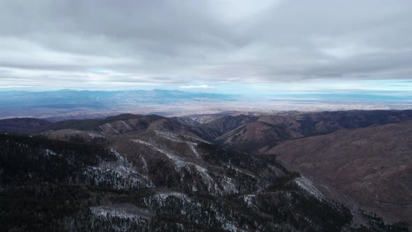 High elevation drone shot of a valley and mountains in the distance alt