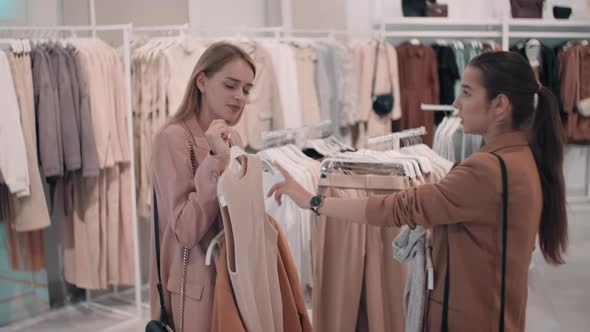 Female Friends Choosing Clothes in Store alt