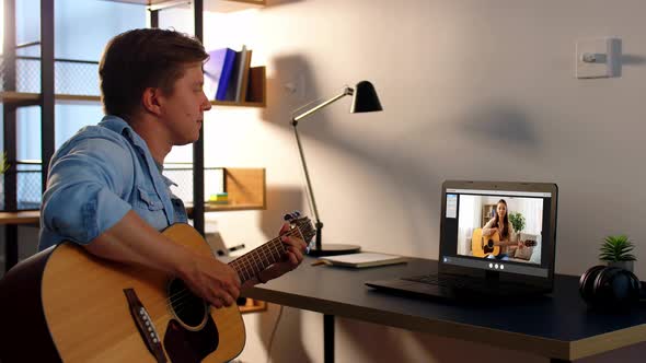 Man Learning To Play Guitar Online at Home alt